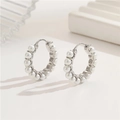 Pendientes de aro plateados con perlas incrustadas en fondo minimalista suave - Paladio