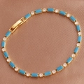 Detailed view of golden bracelet with blue rectangular gems on brown silk background - Peacock Blue Bracelet