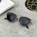 Occhiali da sole cat-eye in metallo da donna con lenti scure su sfondo di pietra - Montatura Oro Lente Grigia