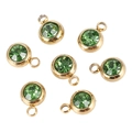 Macro shot of seven gold stainless steel birthstone charms with green crystals - Emerald Green Gold Base