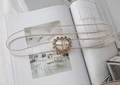 Macro view of gold metal bead belt with rhinestone-encrusted heart buckle on a magazine - Heart Rhinestone Transparent (Gold Beaded Edge)