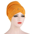Detalle de turbante naranja con cuentas doradas y diseño plisado cruzado en la parte frontal - Amarillo jengibre
