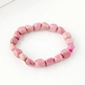 Pink natural irregular tumbled stone bracelet with elastic band on white background - Rhodonite