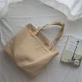 Detalle del bolso tote de lona beige con textura de tela gruesa y asas anchas cómodas - Caqui