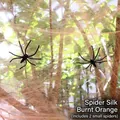 Macro detail of orange Halloween spider web cotton with two small black plastic spiders - 20g Web + 2 Spiders / Orange