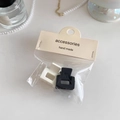 Detail of two matte square hair claws in black and white with premium card packaging - Black+White