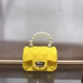 Detail of yellow mini PVC jelly bag with quilted pattern, pearl handle and golden clasp - Yellow