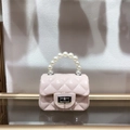 Detail view of pink PVC mini bag with quilted pattern, pearl handle, and metal clasp lock - Apricot