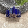 Haarkamm mit blauem Lapislazuli und silbernem Dreifachmond-Symbol auf moosigem Stein - Lapislazuli Silberdraht Silbermond