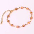 Detailed view of 18K gold chain bracelet featuring small pink enamel daisy flowers - Pink Bracelet