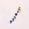 Detail of golden spiral cuff featuring a blue evil eye bead and natural stone pendant - Spiral Pendant / Blue Sapphire Short