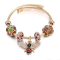 Golden titanium steel braided bracelet with colorful rhinestone beads and a bee pendant - Gold Base Rainbow Rhinestone / Gold