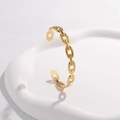 Dettaglio del bracciale a catena dorata minimalista su un vassoio decorativo - Oro