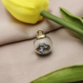 Macro view of a round glass pendant with colorful beads and crystal filling - Colorful