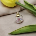 Detail of a clear glass ball pendant filled with pink beads, sequins and a tiny seashell - Pink