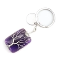 Macro detail of purple crystal Tree of Life pendant with silver wire wrap and metal keyring - Amethyst