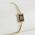 Adjustable golden stainless steel bracelet featuring a black enamel letter B pendant - Letter B