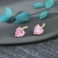 Vista macro di orecchini a cuore con pietre rosa placcati in oro e piccoli diamanti - Rosa