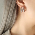 Minimalist double C-shaped earrings in silver finish worn by a model - Silver