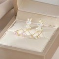Dettaglio macro degli orecchini a coniglio dorati con cuori rosa e zirconi luccicanti - Oro