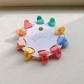 Close-up of 10 colorful heart-shaped mini hair claws in pastel macaron colors on card - Heart