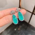 Macro detail of pear-cut Paraiba blue gemstone earrings with clover-shaped silver studs - Paraiba Blue Stud Earrings