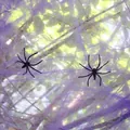 Detail view of purple Halloween spider web cotton with two small black plastic spiders - 20g Web + 2 Spiders / Purple