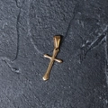 Close-up of a minimalist gold-plated stainless steel cross pendant on a textured dark background - H11 Flat Cross