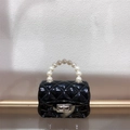 Detail of black mini jelly bag featuring quilted patterns and pearl chain handle design - Black