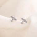 Cute mini silver airplane stud earrings with white crystal wings on fabric background - Airplane Shape / Silver