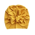 Detail der Baby-Turban-Mütze mit geripptem, ingwergelbem Stoff und großer Strickblume - Gelb