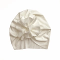 Detailed macro view of white ribbed knit fabric texture on the baby turban hat - White