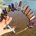Close-up of handmade crescent moon crown with electroplated natural crystals and wire wrap - Deep purple