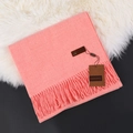 Soft pink cashmere scarf with tassels and brand tag on white fur background - Grapefruit Red