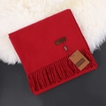 Deep red cashmere scarf with elegant tassels and leather label on white fur rug - Wine Red