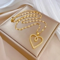 Gros plan du pendentif double cœur doré avec cristaux blancs sur boîte à bijoux - Chaîne de clavicule en forme de cœur / Doré