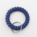 Close-up of matte dark blue spiral telephone cord keychain with a silver metal ring - Royal Blue