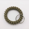 Close-up of military green spiral elastic wristband with durable metal keyring - Grass Green