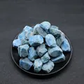 Natural raw blue kyanite mineral stones piled in a black round tray for healing - Blue Goldstone