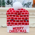 Détail du bonnet de Noël tricoté avec lumières LED et texte Merry Christmas brodé - Motif Mur de Briques Rouges