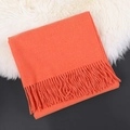 Soft orange cashmere scarf with tassel fringe details on white fur background - Vibrant Orange