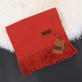 Luxurious soft red cashmere scarf with elegant tassels on a white faux fur surface - Rust Red