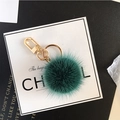 Dark green faux fur pompom keychain with a polished gold metal clip for handbags - Malachite green