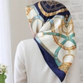 Elegant 90x90cm silk scarf with multi-color patterns shown on a model against a white wall - #9 Harness Chain Blue