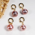 Detailed view of four round iridescent purple pearls with golden metallic ring clasps - Round Baroque Universal Clasp