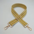 Close-up of yellow and white woven adjustable shoulder strap with gold metal hardware - Yellow