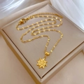Dettaglio della collana con ciondolo a girasole dorato su supporto in pelle beige e seta - Stile Girasole Rotante (M531 Oro) / Oro