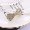 Elegante molletta a fiocco dorato con strass brillanti su pizzo bianco e vassoio - Oro (B6210)
