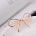 Elegant gold metal hair clip featuring a minimalist linear bow design on a white base - Bow / Gold