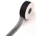 Detailed view of 25 yards of black lace ribbon roll with delicate floral mesh pattern - One Roll / Black